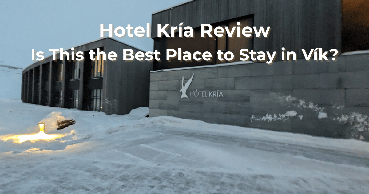Exterior of Hotel Kría in Vík, Iceland during winter with snow-covered mountains in the background.