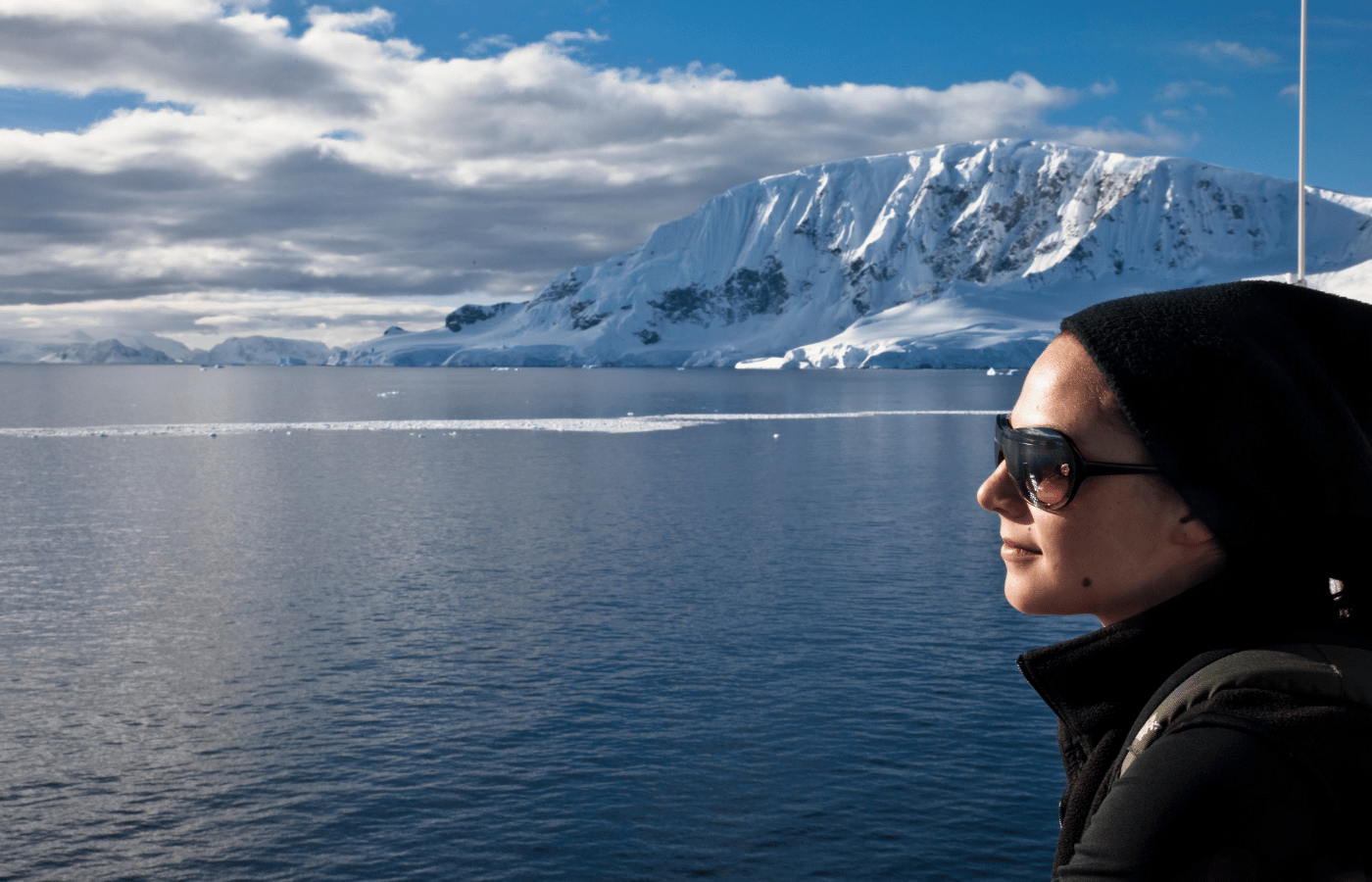 Traveler looking across the Antarctic landscape from an expedition ship balcony