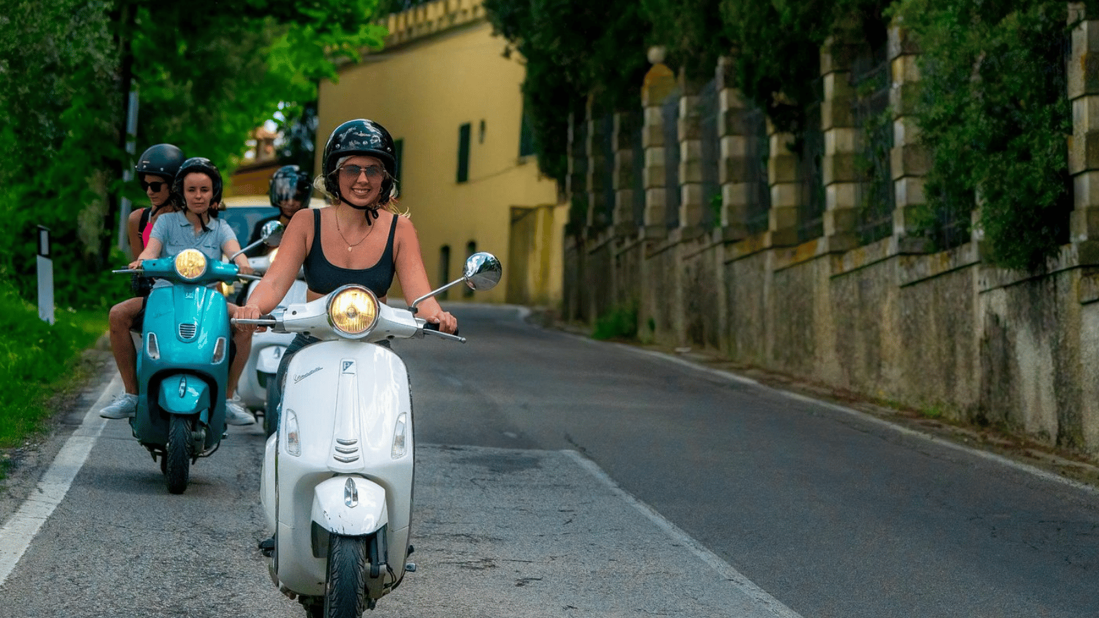 Travelers enjoying a Vespa journey and wine experience in Tuscany