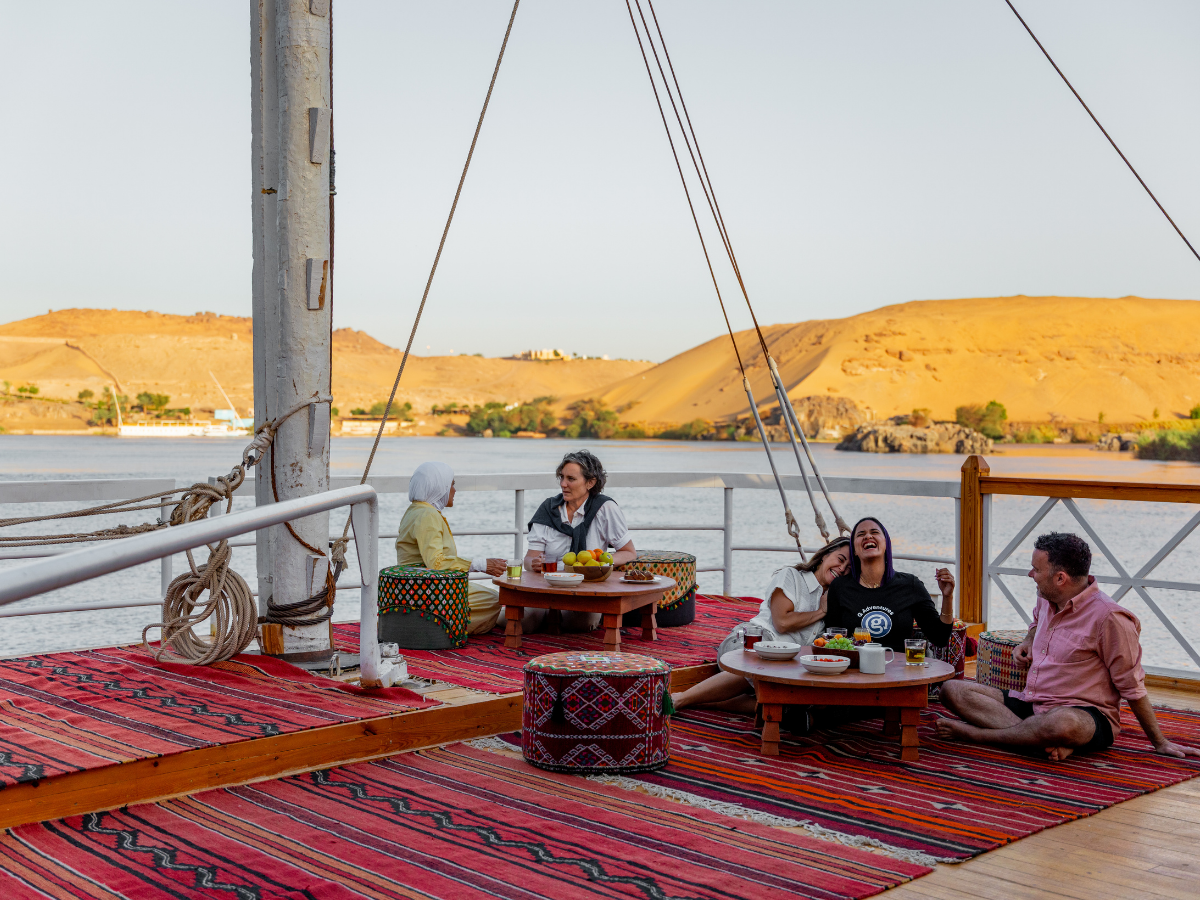 Travelers enjoying dinner aboard a boat sailing on the Nile