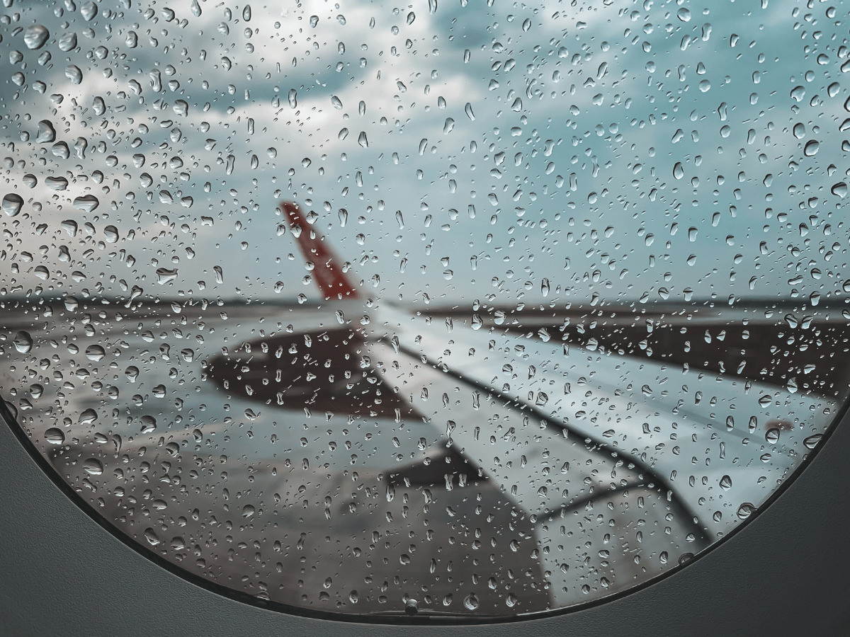 Rain falling outside an airport terminal window
